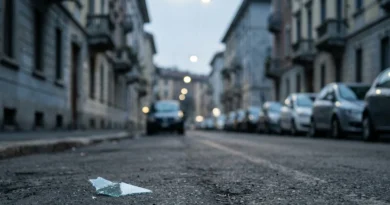Auto rubata cosa fare 2026: frammento di vetro sull'asfalto in una via urbana al crepuscolo