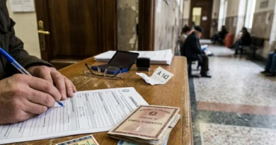 Mano che compila il modulo di richiesta del certificato dei carichi pendenti con la carta d'identità nel corridoio di una Procura